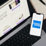 Smartfon z logo American Express leżący na klawiaturze laptopa