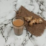 Szklanka indyjskiej herbaty masala chai z plastrem świeżego imbiru