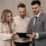 Agent nieruchomości omawia szczegóły mieszkania z parą klientów