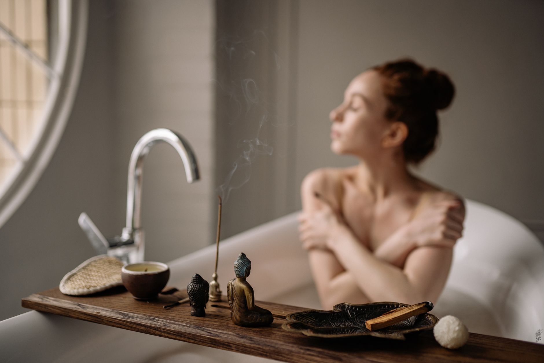 Osoba relaksująca się w kąpieli ajurwedyjnej z miską naturalnych olejów