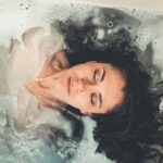 Kobieta w relaksującej kąpieli z pianą, oczy zamknięte, redukcja stresu