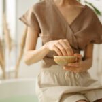 Osoba relaksująca się w kąpieli ajurwedyjnej z miską naturalnych olejów