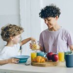 Mama i syn jedzą zdrowe śniadanie w domu