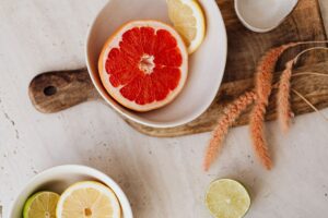 Grejpfrut, cytryna i limonka w miseczkach na drewnianej desce