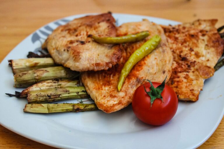 Grillowany kurczak ze szparagami i świeżym pomidorem na talerzu